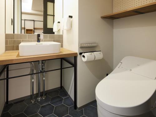a bathroom with a sink and a toilet at LAMP LIGHT BOOKS HOTEL fukuoka in Fukuoka
