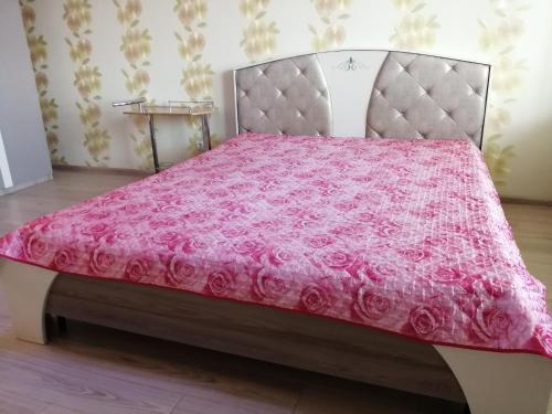 キーロフにあるApartments Azinaのベッド1台(ピンクのベッドカバー付)