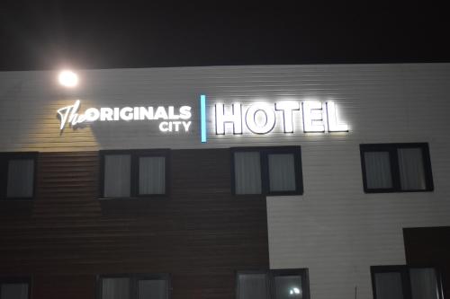 a hotel sign on the side of a building at night at The Originals City, L'Haut' Aile, Coquelles-Calais Tunnel s/Manche L'HAUTAILE in Coquelles