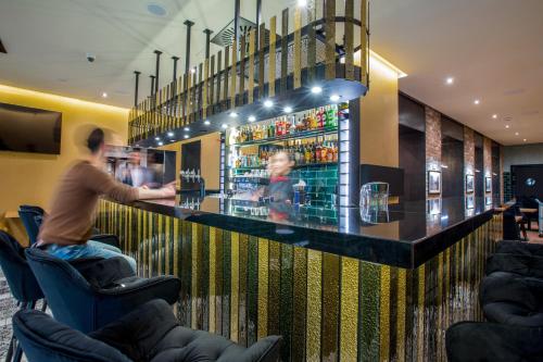 a man sitting at a bar in a restaurant at Hotel Diament Plaza Katowice in Katowice