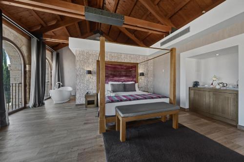 a bedroom with a bed and a tub and a sink at Castilla Termal Monasterio de Valbuena in Valbuena de Duero