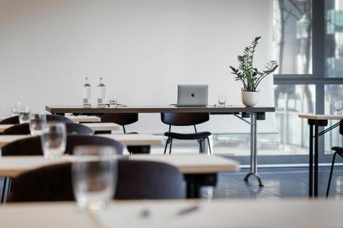 a row of tables and chairs with a laptop on them at Aqua Hotel in Rimini