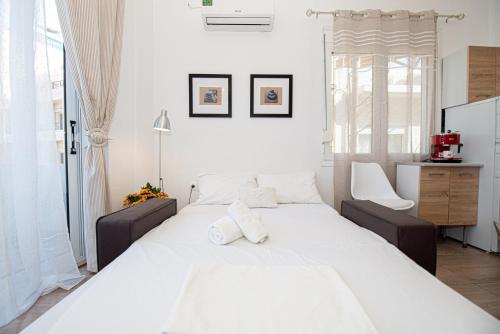 1 dormitorio con 1 cama blanca grande y 1 silla en Ariadni Sea View Apartment en Heraclión