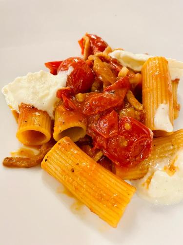 a white plate of pasta with meat and sauce at Aqua Hotel in Rimini