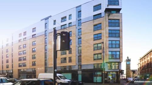 a traffic light in front of a large building at Cosy Apartment in Quiet City-Centre with Car Park in Glasgow