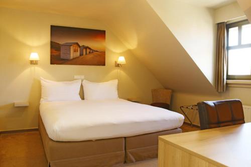 Een bed of bedden in een kamer bij Hotel Les Dunes