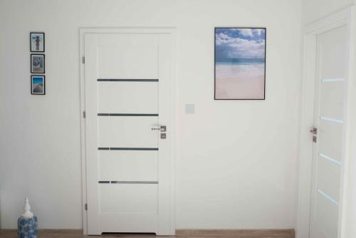 uma porta branca com uma foto em cima em Apartament HAMPTONS Gdynia em Gdynia