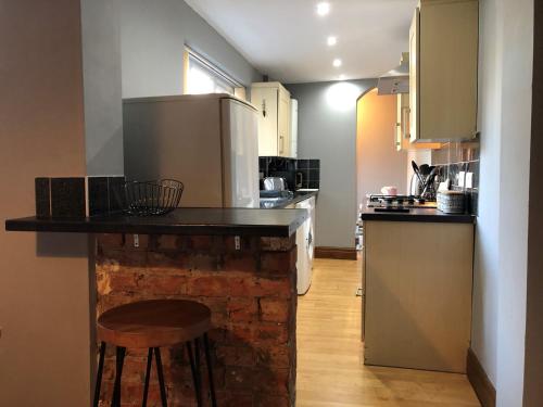 a kitchen with a counter with a refrigerator and a stove at Moss Cottage in Willaston