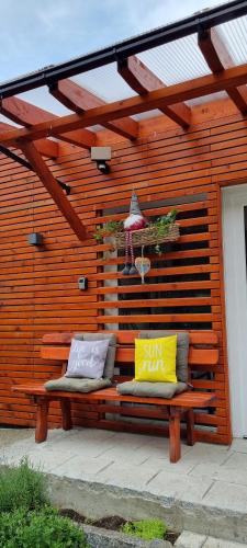 a wooden bench with two pillows sitting on it at APARTMENT WALD - im Skigebiet Gerlitzen & Ossiacher See in Bodensdorf