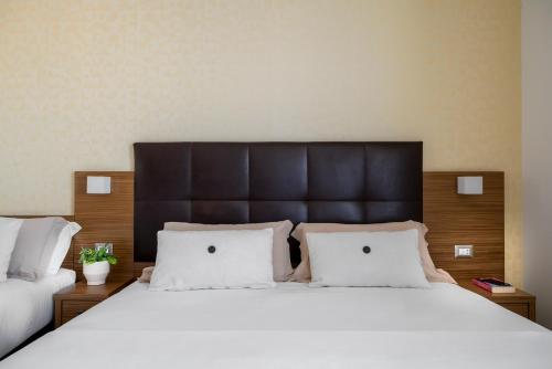 a bedroom with a large white bed with two pillows at Aqua Hotel in Rimini