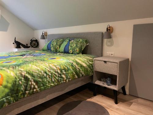 1 dormitorio con 1 cama con edredón verde en Bed en Wellness de Paauw en IJzendijke