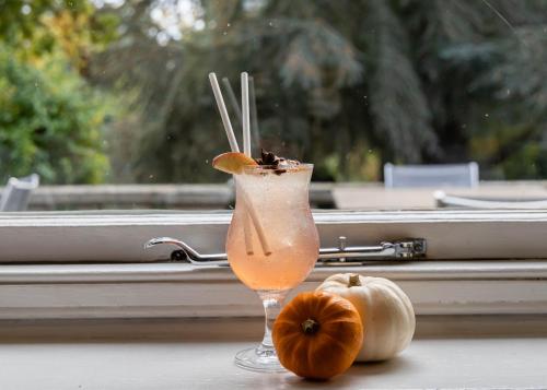 a drink sitting on a table next to two pumpkins at Rowhill Grange Hotel & Utopia Spa in Dartford
