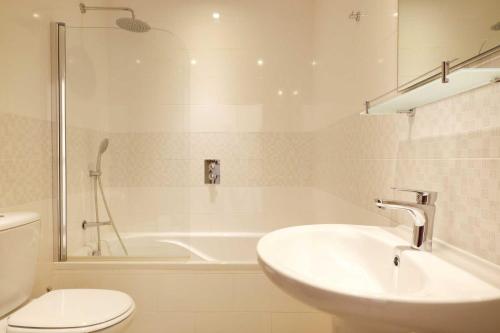 a bathroom with a sink and a tub and a toilet at 3B Waterside in Luz