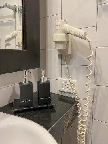 a bathroom with a blow dryer on the wall at Lokal Phuket "Former K-Hotel" - SHA Extra Plus in Patong Beach