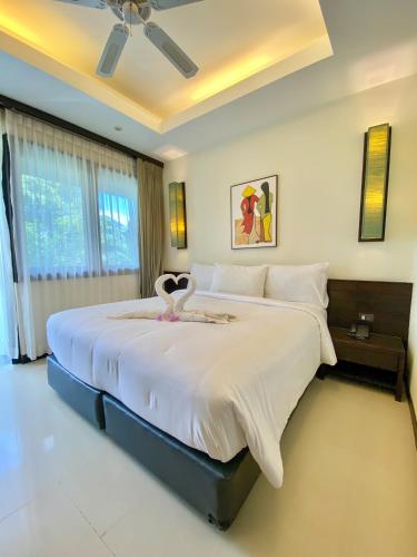 a bedroom with a large bed with a large white bedspread at Lokal Phuket "Former K-Hotel" - SHA Extra Plus in Patong Beach