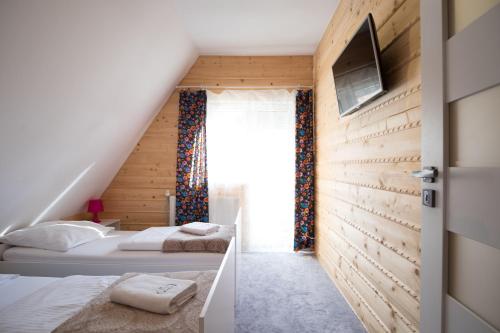 een slaapkamer met twee bedden en een raam bij Admi Zakopane in Zakopane