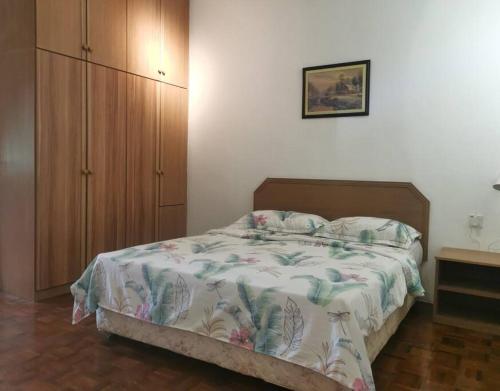 a bedroom with a bed and a wooden cabinet at Cozy NEAR-BEACH Apartment - LazyCats' Den in Batu Ferringhi