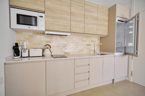 a kitchen with white cabinets and a microwave at Slow Home Apartments in Valencia