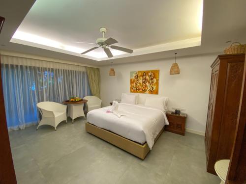 a bedroom with a bed and a ceiling fan at Lokal Phuket "Former K-Hotel" - SHA Extra Plus in Patong Beach