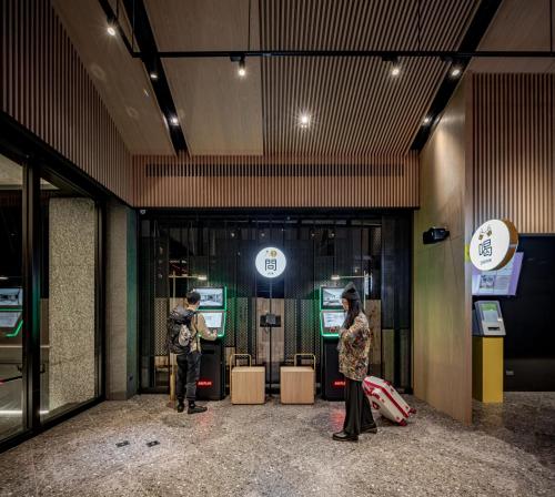 two people standing inside of a building with at The Moment Hotel Hualien by Lakeshore in Shunan