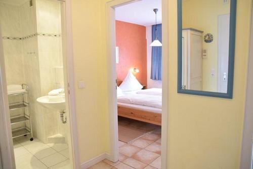 een badkamer met een slaapkamer met een bed en een spiegel bij App-Stadtoase-Haus-Nordland in Westerland