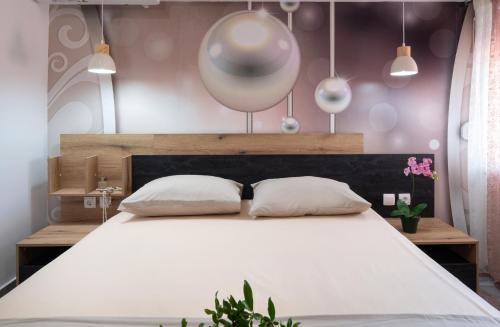 - une chambre avec un grand lit blanc et 2 oreillers dans l'établissement ViLLA DRAGANI, à Sikia