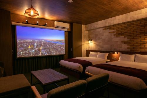 une chambre d'hôtel avec deux lits et une grande fenêtre dans l'établissement RESI STAY BRiX, à Kyoto