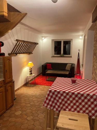 a living room with a table and a couch at La petite maison de la vallée in Bazainville