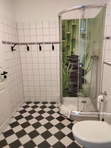 a bathroom with a shower with a toilet and a fish tank at Hotel Gunia in Berlin