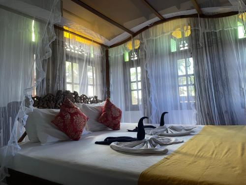 een slaapkamer met een groot bed met 2 zwanen erop bij Flamingo Guest house in Unawatuna