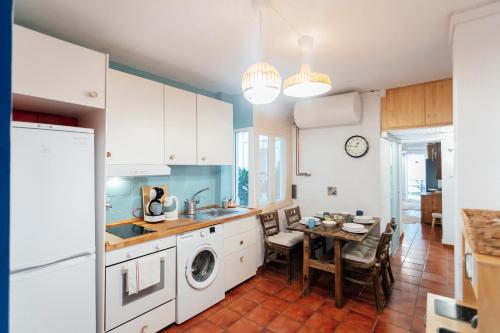 eine Küche mit einer Waschmaschine, einem Trockner und einem Tisch in der Unterkunft Alohamundi San Basilio in Sevilla