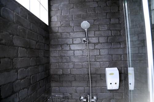 een douche in een bakstenen muur met een föhn bij Ático Plaza Mercado 4,5 in Salamanca