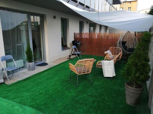 a lawn with chairs and an umbrella and a camera at Apartament Przytulny in Kołobrzeg