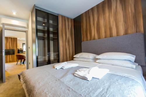 una camera da letto con un grande letto con lenzuola e cuscini bianchi di Villa Braga a6 a Baška Voda