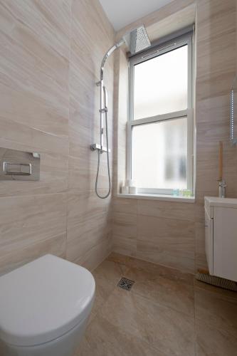 a bathroom with a toilet and a window and a shower at Fabulous Apartment in Superb location in London