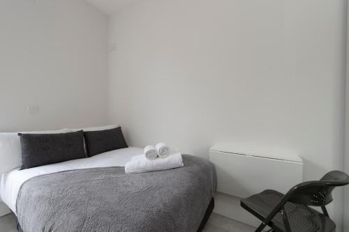 a bedroom with a bed with two towels on it at Fabulous Apartment in Superb location in London
