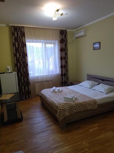 トゥリスキーにあるTulsky Lago-Naki Guest Houseのベッドルーム(大型ベッド1台、窓付)