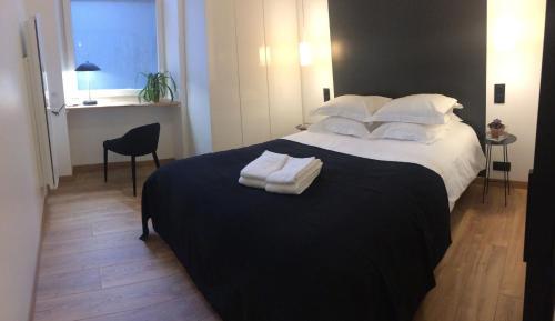 une chambre avec un grand lit avec des serviettes dessus dans l'établissement LE NID DES ROIS, à 2 pas de la Cathédrale, à Reims