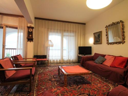 a living room with a couch and a table at Apartment Lungolago by Interhome in Lavena Ponte Tresa