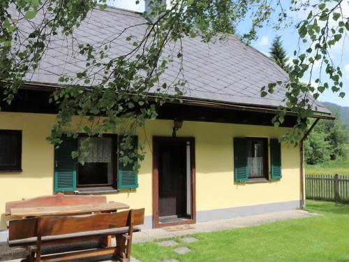 a yellow house with green shutters and a bench at Holiday Home Richter by Interhome in Zistl