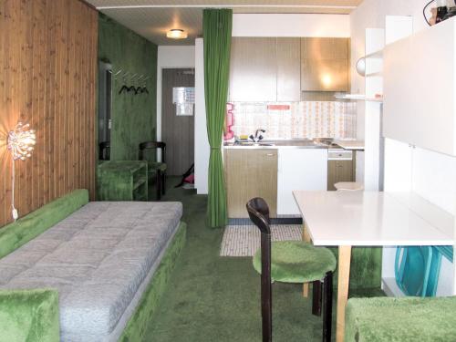 a bedroom with a bed and a table and a kitchen at Studio Résidence Velan-2 by Interhome in Les Collons