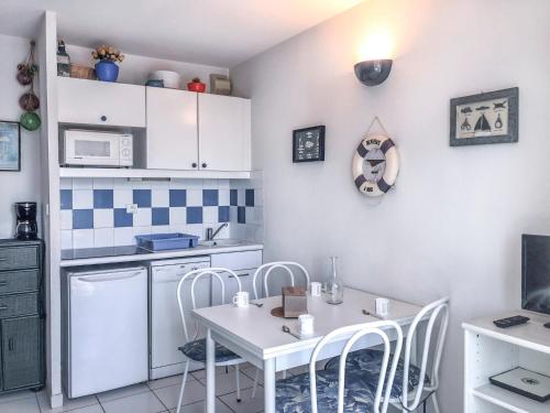 een kleine keuken met een witte tafel en stoelen bij Apartment La Palme d'Or-16 by Interhome in Cap d'Agde