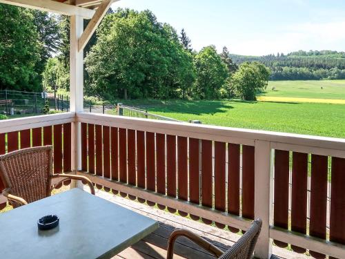 eine Veranda mit einem Tisch und Stühlen sowie Blick auf ein Feld in der Unterkunft Holiday Home Erzeberg-3 by Interhome in Balhorn