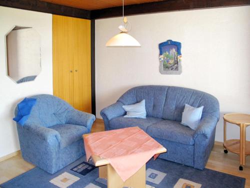 uma sala de estar com um sofá azul e uma cadeira em Holiday Home Jägerwiesen - WAH104 by Interhome em Waldkirchen