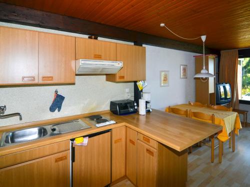una cucina con armadi in legno e piano di lavoro di Holiday Home Jägerwiesen - WAH104 by Interhome a Waldkirchen