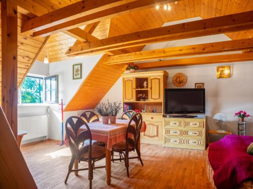 a dining room with a table and chairs and a television at Holiday Home Karasova III by Interhome in Dehtáře