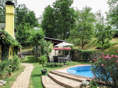 a backyard with a pool and a table and an umbrella at Holiday Home Karasova III by Interhome in Dehtáře