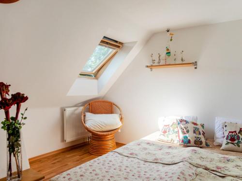 a bedroom with two beds and a chair at Holiday Home Karasova III by Interhome in Dehtáře
