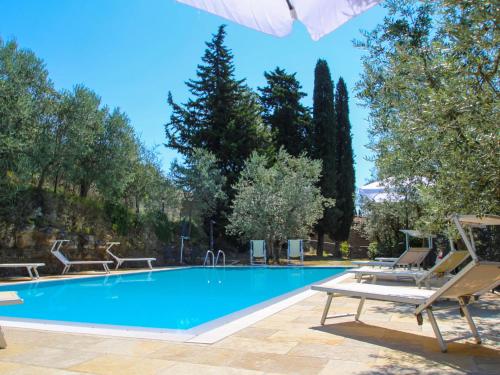 una gran piscina con tumbonas y árboles en Holiday Home Podere Le Coste by Interhome, en Paterna
