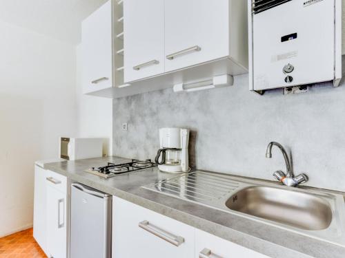 a kitchen with white cabinets and a sink at Apartment Les Mas de la Garrigue I et II-1 by Interhome in Cap d'Agde